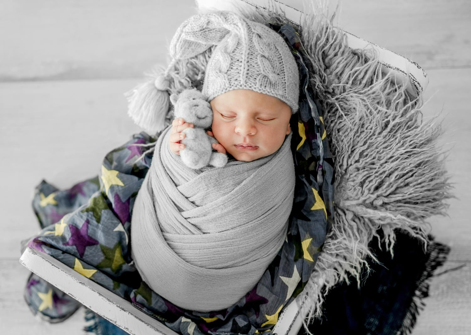 Parent marchant en hiver avec un bébé installé en portage ventral sous une couverture de portage chaude et coupe-vent
