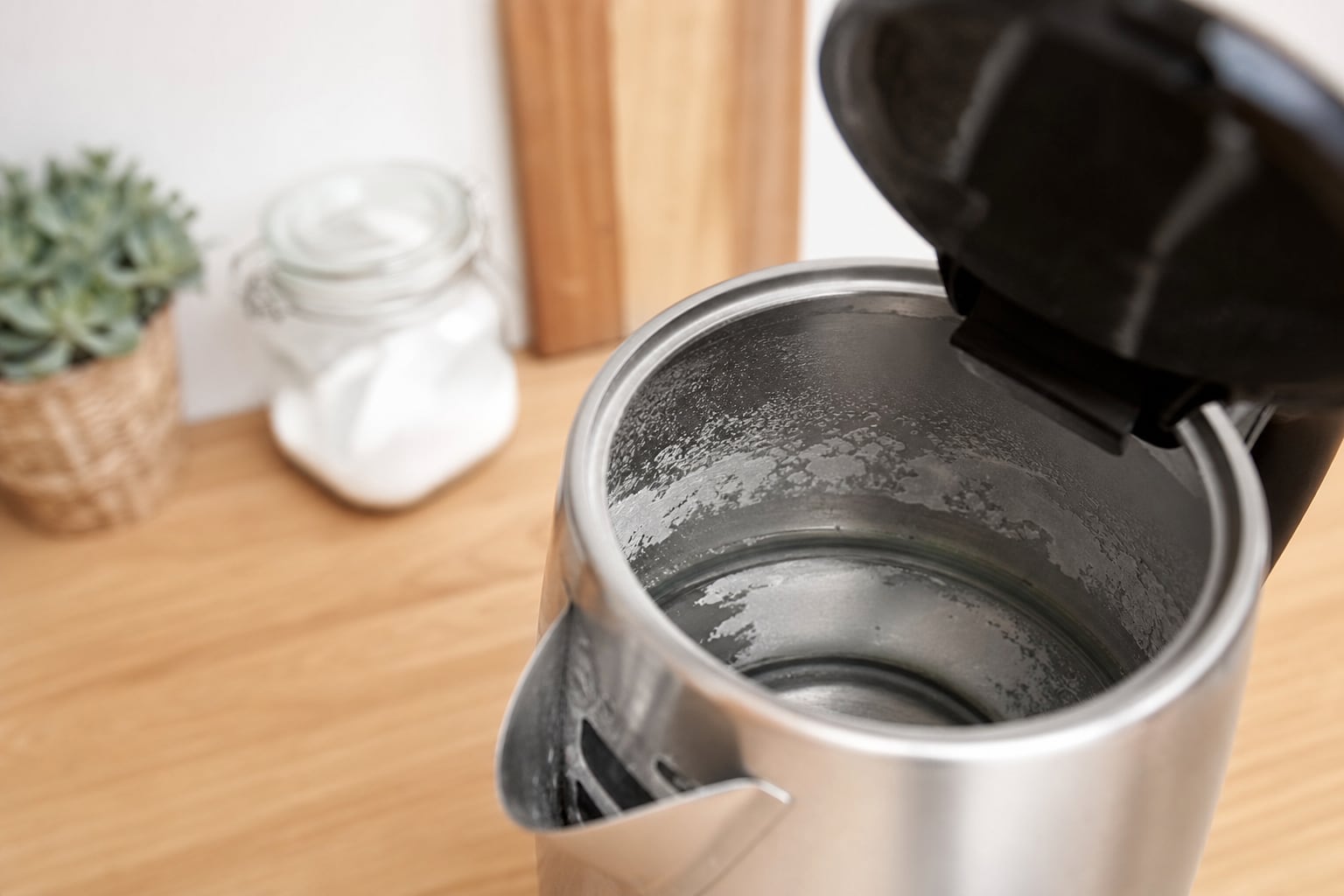 Bouilloire électrique posée sur un plan de travail de cuisine, avec de la vapeur s'échappant du bec verseur