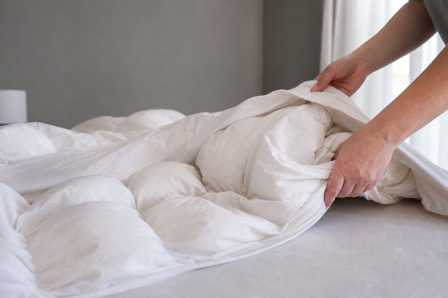 Couette étalée sur un lit avec un garnissage inégal formant des amas visibles